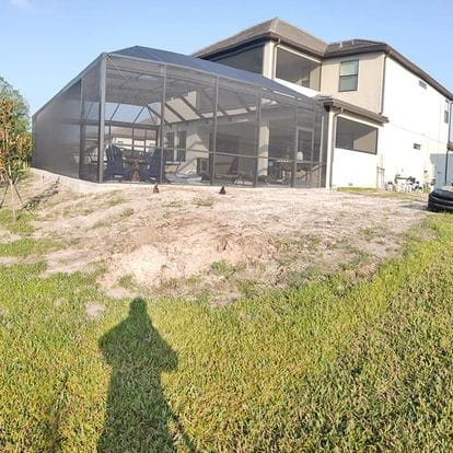 Landscaped property featuring a house with a screened-in porch